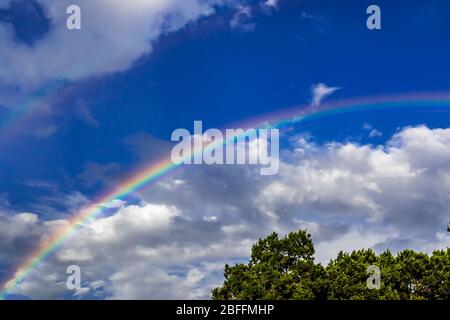 Rainbow contro un cielo blu con nuvole Foto Stock
