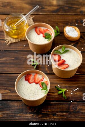 Tre tazze di carta artigianale con budino di tapioca con latte a base di piante Foto Stock