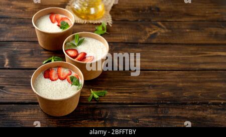 Tre tazze di carta artigianale con budino di tapioca con latte a base di piante Foto Stock