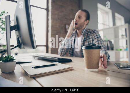 Sfocata foto fuoco di bel business ragazzo guardare monitor computer sul tavolo fine scadenza rapporto in tempo bisogno di un po 'di caffè prendere fresco tazza di imbardata Foto Stock