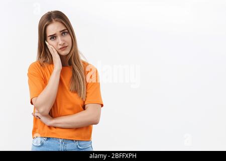 Ritratto di bionda travagliata, penosa incastrata in una situazione difficile, sentirsi inquieto e frustrato, sospirando, tenere la mano sul viso, guardando ansioso e. Foto Stock