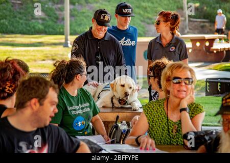 Gli escursionisti civili di cani sono Uniti dalla polizia locale ad una conferenza all'aperto sulla responsabilità civile per gli escursionisti pedonali di cani in un parco a Corona, CA. Foto Stock