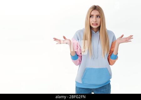 Ragazza nervosa, ansimante senza esclusione di circolo con capelli lunghi biondi, shrugging e spalmare le mani lateralmente, facendo errore sentire imbarazzato e preoccupato qualcuno può Foto Stock