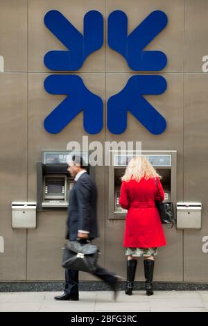 Una donna con un RBS sportello bancomat. Foto Stock