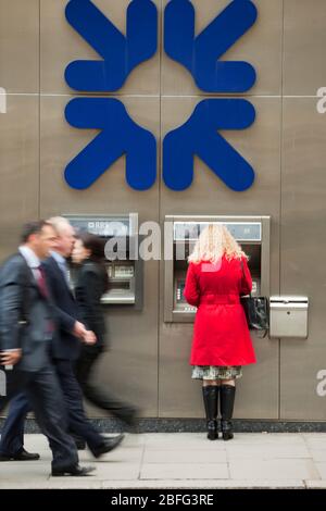 Una donna con un RBS sportello bancomat. Foto Stock