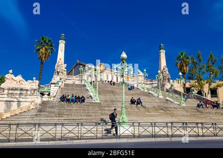 Persone sedute su scale fuori dalla stazione ferroviaria edificio Gare de Marseille-Saint-Charles, Marsiglia, Francia Foto Stock