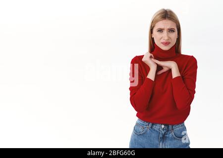 Concetto di lavoro, carriera e stile di vita. Ritratto di donna bionda, scottante e ignorante, che grida a qualcosa di disgustoso, che tocca mani afflitte e che squinting Foto Stock