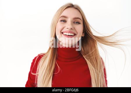 Bellezza, donna e concetto di moda. Primo piano ritratto di bella, romantica donna caucasica con capelli lunghi biondi galleggianti in aria, sorridenti e. Foto Stock