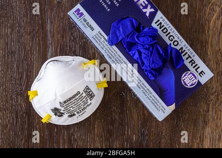 BELLEVUE, WA/USA – 18 APRILE 2020: Forniture di sicurezza PPE su un tavolo in legno, maschera N95 e guanti monouso in nitrile Foto Stock