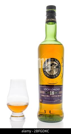 Winneconne, WI - 12 aprile 2020: Una bottiglia di whisky di 18 anni di Loch lomond single malt Scotch con un bicchiere Glencairn su sfondo isolato. Foto Stock