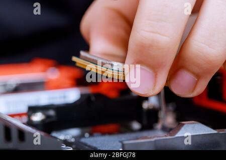 Tecnico che installa la CPU hardware del computer sulla scheda madre Foto Stock