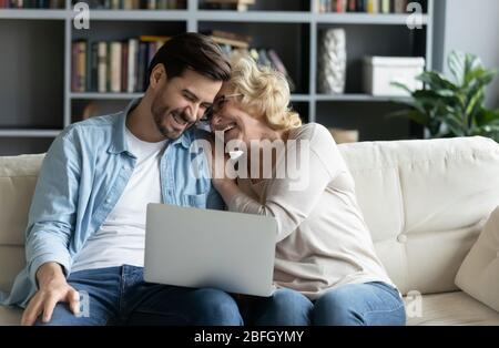 Ridendo il figlio adulto e la madre anziana che guardano sulla commedia del laptop Foto Stock