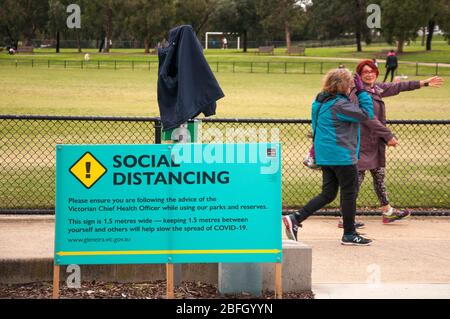 L'avviso del governo locale in un parco suburbano promuove le distanze sociali durante la pandemia COVID-19, Melbourne, Australia Foto Stock