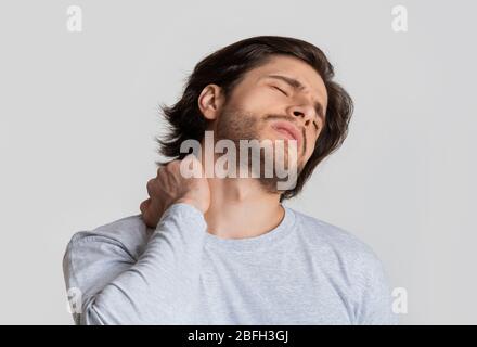 Dolore al collo. Guy preme la mano per irritare il punto Foto Stock