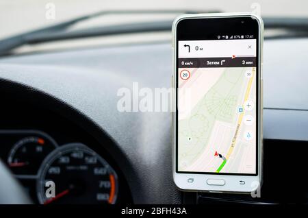 Smartphone in auto per navigare o utilizzare il GPS. Guida di un'auto con telefono in supporto. Foto Stock