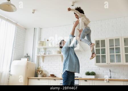 Buon papà che gioca con la figlia biraciale a casa Foto Stock