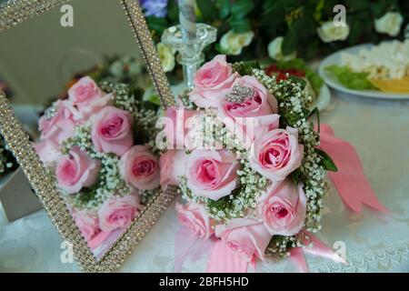nastro rosa .fiori di impegno rosa su tavolo bianco . Lo specchio della rosa è specchio, mentre il contrario delle rose rosa di matrimonio cade nello specchio Foto Stock