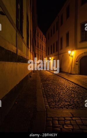 Vista notturna di vicoli stretti attraverso edifici alti e sentieri acciottolati nella Città Vecchia, Praga, Repubblica Ceca Foto Stock