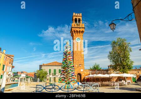 Torre dell'Orologio di Murano chiesa di San Stefano e colorato albero di natale in vetro di Murano su piazza campo Santo Stefano a Murano Foto Stock