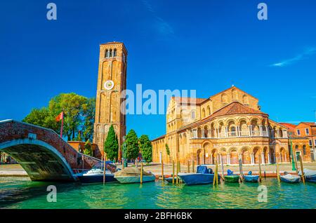 Chiesa di Santa Maria e San Donato e campanile edificio in mattoni, ponte sul canale d'acqua con barche a motore in Murano isole, provincia di Venezia, VE Foto Stock