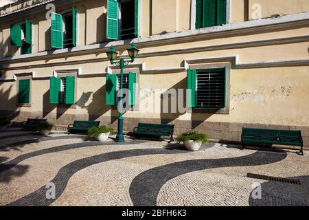 Tradizionale portoghese ondulato strada acciottolata piastrelle nel quartiere storico di Macau, Cina. Foto Stock