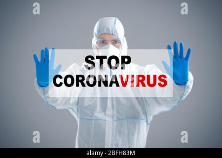 Concetto di protezione della popolazione. Uomo che tiene iscrizione stop coronavirus Foto Stock