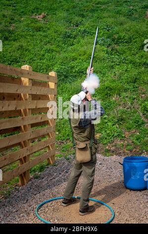 Un'antica pistola di blocco della selce sparata da un uomo durante una competizione di tiro al piccione di argilla (Nota: Questo è il numero 1 in una serie di 6 colpi che mostrano il fumo dalla pistola durante il tiro) Foto Stock