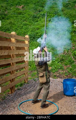 Un'antica pistola di blocco della selce sparata da un uomo durante una competizione di tiro al piccione di argilla (nota: Questo è il numero 4 in una serie di 6 colpi che mostrano il fumo dalla pistola durante il tiro) Foto Stock