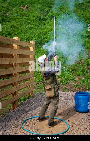 Un'antica pistola di blocco della selce sparata da un uomo durante una competizione di tiro al piccione di argilla (nota: Questo è il numero 5 in una serie di 6 colpi che mostrano il fumo dalla pistola durante il tiro) Foto Stock