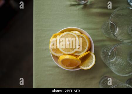 Fette di limone in una ciotola posta sul tavolo. Foto Stock