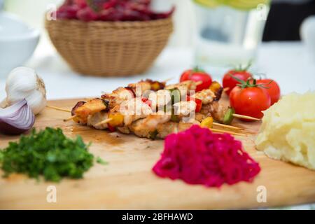 Set di Shish Kebab . Kebab di manzo su un asse di legno . Crauti di cavolo rosso . purè di patate . Aglio, cipolla, pomodori. Coriandolo tritato . Agnello Foto Stock