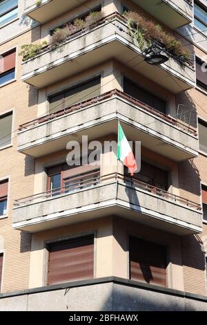 Bandiere nazionali italiane appese sui balconi di Milano. Gli italiani appendono bandiere sui loro balconi per sostenere il paese durante l'emergenza del Covid 19. Foto Stock