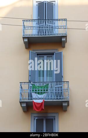 Bandiere nazionali italiane appese sui balconi di Milano. Gli italiani appendono bandiere sui loro balconi per sostenere il paese durante l'emergenza del Covid 19. Foto Stock