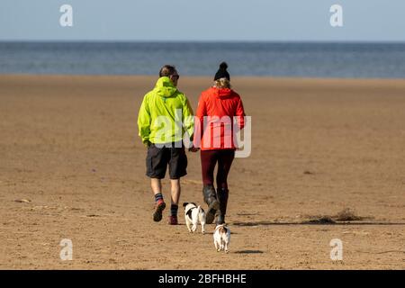 Southport, Merseyside. Meteo Regno Unito. 19 Apr 2020. Ancora un'altra luminosa giornata di primavera di aprile nella località balneare, mentre i residenti locali si allenano alla luce sulle vaste sabbie costiere sulla spiaggia di Ainsdale nord-occidentale. Il Ministro Michael Gove ha affermato che è troppo presto per abolire le restrizioni alla circolazione delle persone e che le regole di allontanamento sociale devono continuare ad applicarsi per un certo periodo di tempo. Credit: MediaWorldImages/AlamyLiveNews Foto Stock