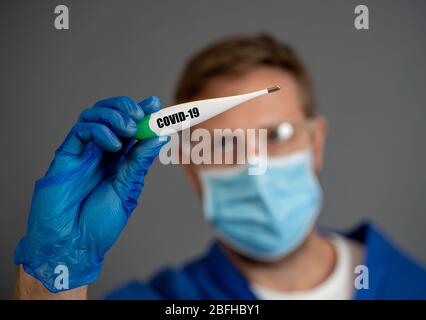 Focolaio COVID-19. Termometro con supporto medico. Proteggersi e prevenire la diffusione del coronavirus. Se ha sintomi, febbre, tosse e diff Foto Stock