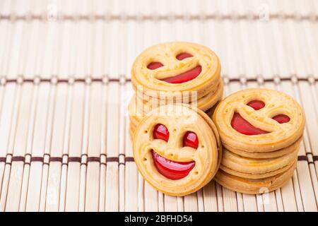 biscotti sorridenti alla marmellata di fragole. Foto ravvicinata Foto Stock