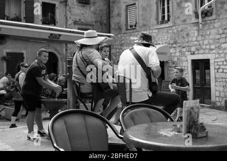 Cattaro, Montenegro, 17 settembre 2019: Vista da dietro di un duo chitarrista e ragazzi locali che ballano nella piazza della città Foto Stock