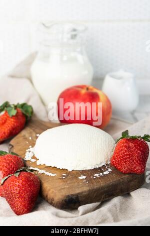 Preparazione fatta in casa, formaggio cremoso naturale fatto in casa su uno sfondo chiaro su un legno Board Foto Stock