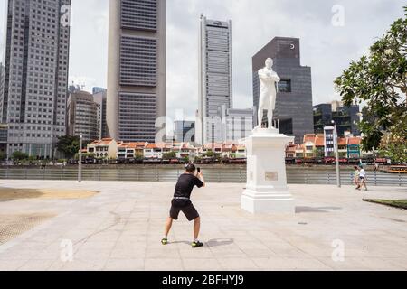Singapore / Singapore - 15 febbraio 2019: Turista asiatico fotografare la scultura in una posizione strana nella città di Singapore Foto Stock