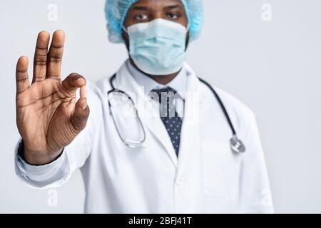 Medico afro americano maschile che raccomanda di tenere pillola Foto Stock