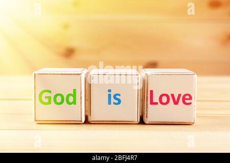 Il testo di Dio è Amore scritto a cubetti su sfondo di legno Foto Stock