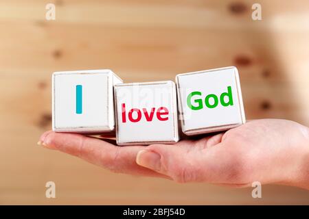 Amo il testo di Dio scritto in cubetti su sfondo di legno Foto Stock