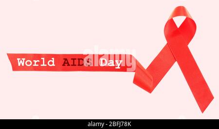 Nastro rosso AIDS su sfondo chiaro Foto Stock