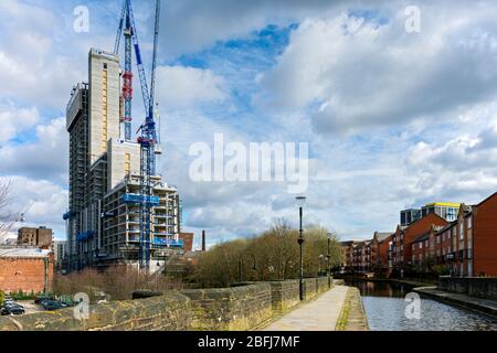 L'edificio di appartamenti della Oxygen Tower (in costruzione) dall'acquedotto di Store Street sul canale Ashton, Manchester, Inghilterra, Regno Unito Foto Stock