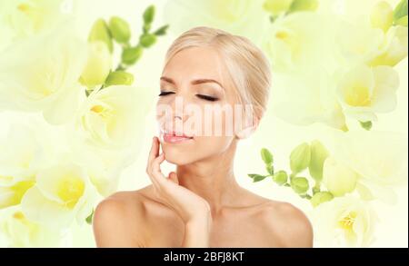 Bella giovane donna su sfondo fiore freesia Foto Stock