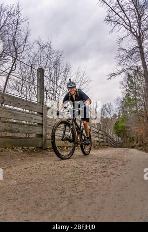 Mountain biker in una giornata nuvolosa bagnata Foto Stock