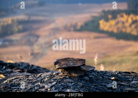 Caucaso, Georgia, regione di Tusheti, Omalo. Pietre impilate a terra con montagne sullo sfondo all'alba Foto Stock
