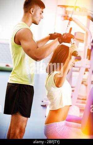 Ragazza giovane e allenatore in palestra Foto Stock