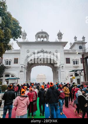 Persone all'ingresso del Tempio d'Oro, Amritsar Foto Stock