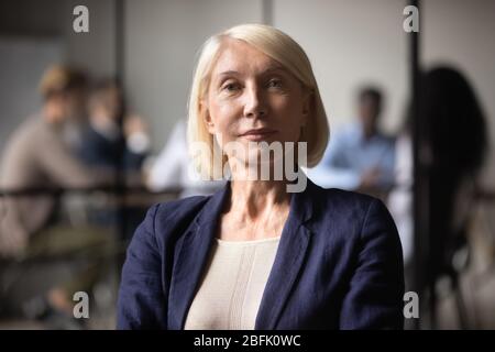 Ritratto headshot di una donna d'affari di mezza età che posa in ufficio Foto Stock